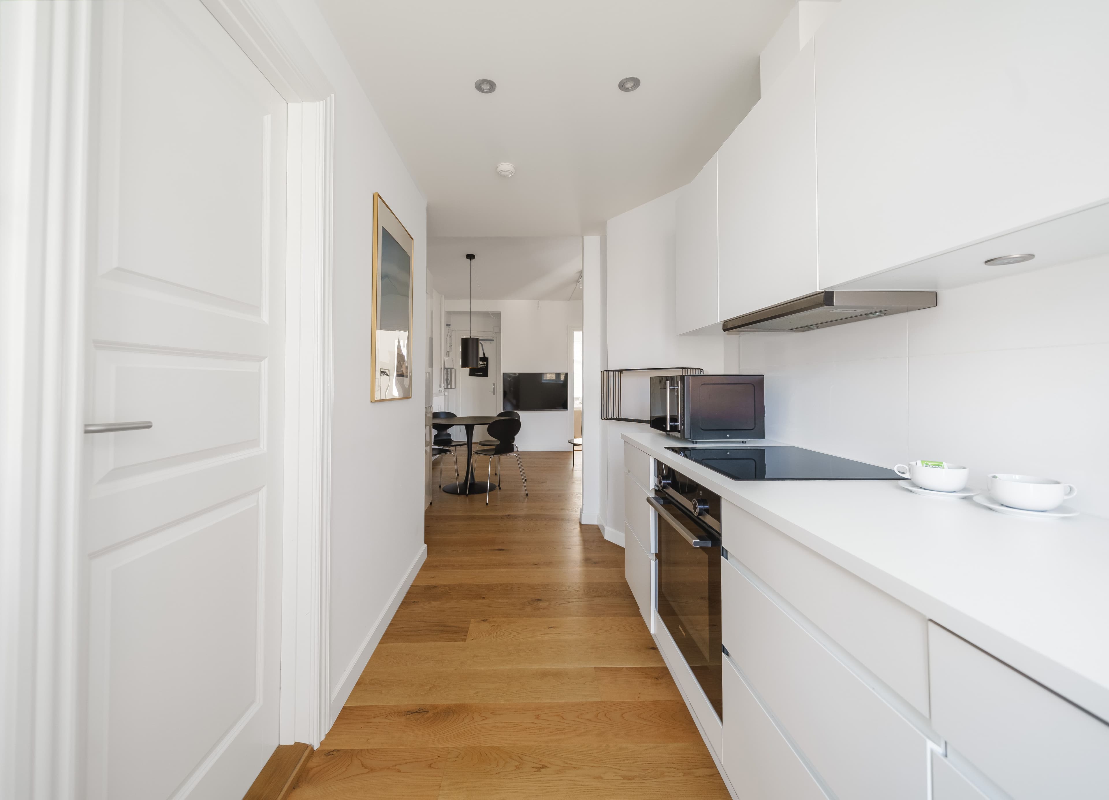 A hallway with a kitchen with a white countertop